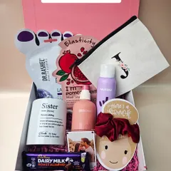 Pamper your sister with this Rakhi hamper, filled with self-care goodies, a custom initial pouch, a personalized mug, and her favorite chocolate.