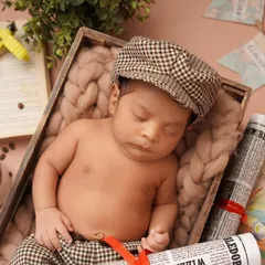 A different angle from our little traveler's photoshoot. This setup includes vintage props like a newspaper, an open book, and a toy plane to create a rich, narrative-driven portrait.