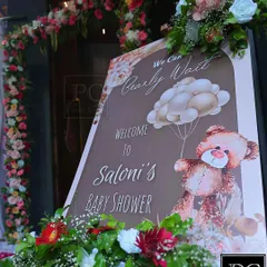 A personalized welcome sign for Saloni's baby shower, featuring the sweet "We Can Bearly Wait" theme. The sign is beautifully framed with fresh flowers, setting a warm and inviting tone.