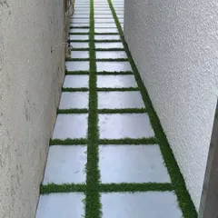 This project shows a creative use of artificial grass in a narrow side yard. I installed synthetic turf between large concrete pavers to create a unique and visually interesting walkway that is both functional and green.