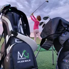 A young golfer perfects her swing against the evening sky. My academy provides the ideal setting for dedicated practice, helping aspiring players hone their skills.