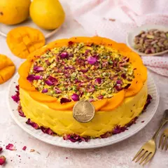 This is our Mango Pistachio Rose Cake, an elegant twist on a classic. We blend fresh mango pulp into the cream, then top it with sliced mangoes, crushed pistachios, and edible rose petals for a truly gourmet experience.