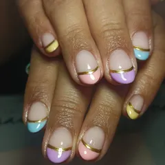 I am obsessed with this creative take on the French manicure. This look features soft pastel tips in pink, lilac, yellow, and blue on natural nails, accented with a clean gold stripe for a chic finish. A strengthening gel overlay ensures the design lasts and helps your nails grow strong.
