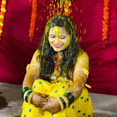 The bride is showered with love and turmeric during a lively Haldi ceremony, a moment of pure, uninhibited joy.