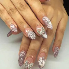 Intricate and stunning. These long almond nails feature 3D shell textures and are adorned with silver butterfly charms made of tiny crystals.