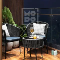 A closer look at the intimate seating arrangement on this balcony. The woven chairs and matching table create a perfect setting for two to enjoy the city view.