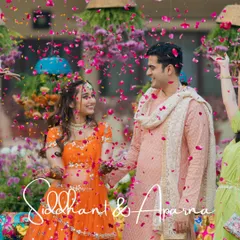 A picture-perfect moment from a Mehendi ceremony, with the couple framed by a shower of rose petals. The vibrant colors and their happy expressions make this a standout shot.