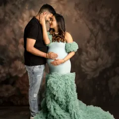 The connection between partners is a beautiful part of the maternity story. This intimate couple's portrait, set against a soft floral backdrop, captures a quiet moment of love and anticipation.
