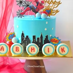 A closer look at the details on the Spider-Man cake, showing the personalized "ABHIK" discs and the action-packed toppers.