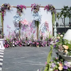 The photo backdrop for the 'Victorian Bageecha' mehendi, featuring a hand-painted floral panel, 3D paper flowers, and lush, real floral arrangements.