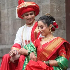 A beautiful moment between the couple in their traditional Maharashtrian wedding attire. The groom's look is authentic, featuring a perfectly styled Pheta and natural makeup for a fresh appearance.