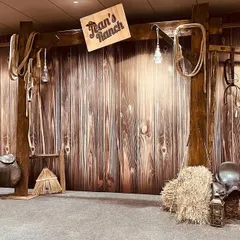 A rustic 'Jean's Ranch' themed photo corner we created for a corporate event. We used authentic props like hay bales, saddles, and a wooden backdrop to transport guests to a different world.