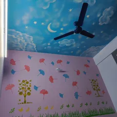 A complete look at a child's bedroom where we combined a sky mural on the ceiling with colorful stencils of trees, grass, and leaves on the walls. This creates a playful and immersive environment for kids.