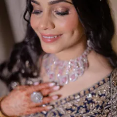 A soft, romantic shot of the bride, her eyes closed, showcasing the beautiful blend of her eyeshadow. The sparkling diamond necklace adds to the glamour.
