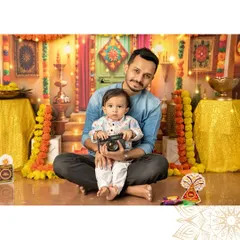 A father and son moment from a Diwali themed session. The little one is holding a vintage camera prop, adding a playful touch to this festive father-son portrait.