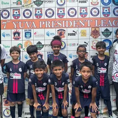 Our U9 team stands with their coaches before a Yuva President League match. This image shows the focus and unity of our young players as they prepare to compete.