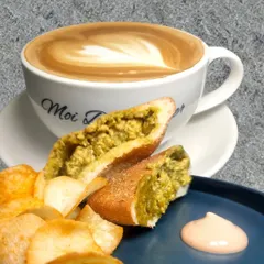 The perfect pairing. A creamy latte with beautiful heart art sits next to my flavourful Poee Cafreal sandwich, served with a side of crispy chips and dip.