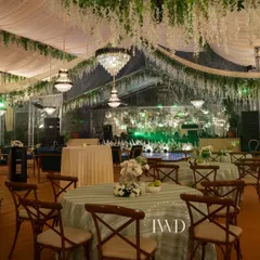 The seating arrangement for the enchanted garden Sangeet. Crystal chandeliers hang from the floral ceiling, casting a magical glow over the entire space.