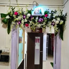 This minimalist door decoration proves that less can be more. A beautiful arrangement of fresh orchids and foliage placed above the door adds a touch of class, perfect for a housewarming or intimate gathering.