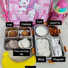 Another balanced meal idea for the tiffin box. This meal contains plain and ragi idly for breakfast, and for lunch, rice with carrot fry, chapathi, and curd. A banana and cookies are included for snacks.