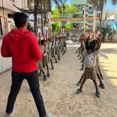 An outdoor drill session with school-aged children. The instructor leads them in synchronized movements, building discipline and fitness in the fresh air.