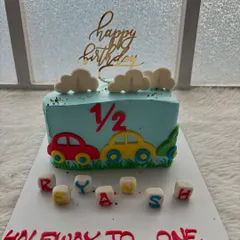 A cute car-themed half-cake for a six-month celebration. It's a fun way to mark this special milestone.
