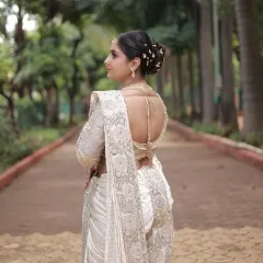 A view of the back of the white Nauvari, showing the elegant hairstyle and the beautiful drape of the saree.