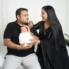 The beginning of a new life as a family. The parents look at each other with so much love while the father gently cradles their sleeping newborn.