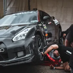 A closer look at the pit crew making final adjustments. The teamwork and focus in the paddock are just as intense as the action on the track.
