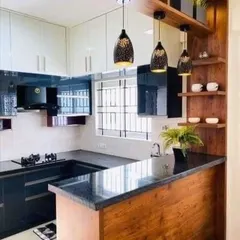 This kitchen features a peninsula that separates the cooking area from the living space while providing a cozy breakfast counter. The design combines wood and black gloss for a modern look.