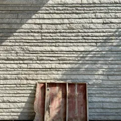 A work-in-progress shot showing a section of formwork used for concrete, resting against a newly completed wall of hand-chiseled stone. This image captures the two materials that are central to our practice: the raw and the crafted.