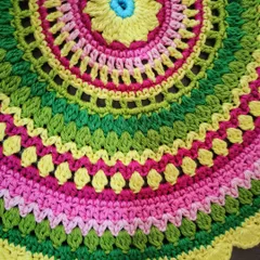 A close-up of the intricate stitches in the Viola mandala. The pattern includes puff stitches and post stitches that create wonderful texture and detail.