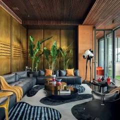 A wider view of the lounge in the Nadhyavart project, showing how the space opens onto a terrace. The design seamlessly connects the indoor and outdoor areas, flooding the interior with natural light and creating a living space that feels perpetually connected to its surroundings.