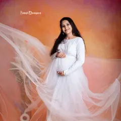 An angelic and dreamy portrait. The flowing white gown and soft studio lighting create a heavenly look for this beautiful mother-to-be.