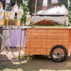 A chef preparing a dish with dramatic flair at a live station. The steam and action from the live cooking add an element of entertainment for guests at the event.