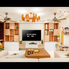 This view highlights the custom-built media wall with integrated shelving and rattan-detailed cabinets. The symmetrical design creates a sense of balance, while the warm wood tones add a touch of natural elegance.