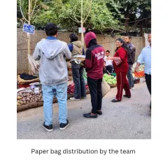 Our team distributing paper bags at a local Wednesday market. We regularly monitor these markets and work with vendors to encourage a shift away from single-use plastics.