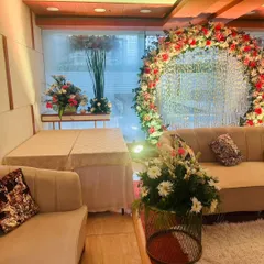 This is a stunning engagement or ring ceremony setup with a circular arch decorated with red and white flowers. The backdrop features a curtain of crystals that sparkles in the light, creating a glamorous effect.