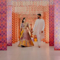 An entrance should be the beginning of the magic. For this Garba night, we designed a captivating tunnel using traditional bandhani-inspired prints and cascading floral strings, creating a vibrant and immersive walkway for the couple and their guests.