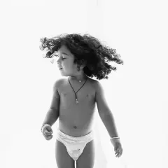 A candid moment of a child dancing, with his curly hair flying. Black and white enhances the sense of movement and freedom.
