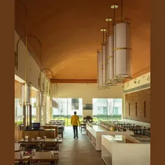 The hotel's cafe, where high, vaulted terracotta ceilings and large windows create an airy, light-filled dining space that feels both expansive and welcoming.