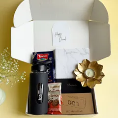 This corporate gift box for TCS combines utility and indulgence. It includes a branded water bottle, an LED mirror clock, a marble-finish notebook, and gourmet snacks.