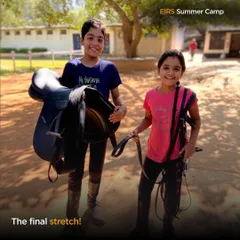 The final stretch of summer camp is full of smiles. Campers learn to carry their own tack, a small but important step in becoming responsible and independent equestrians.