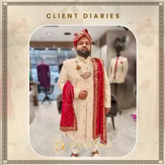This groom is ready for his big day in a custom-made ivory sherwani with delicate embroidery, a matching necklace, and a vibrant red pagri and stole. It's a complete, majestic look.