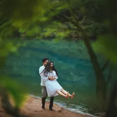A playful lift at the edge of a crystal-clear lake. The natural framing from the leaves adds an intimate, secret-garden feel to this fun and candid couple portrait.