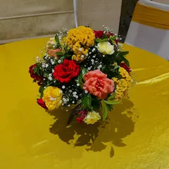 A colorful floral centerpiece for a table at an event. I used a mix of red, yellow, and pink flowers with baby's breath to create this beautiful arrangement.