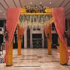 A closer view of the indoor mandap entrance. The sequined peach drapes and hanging white flowers add a touch of glamour to the traditional structure.