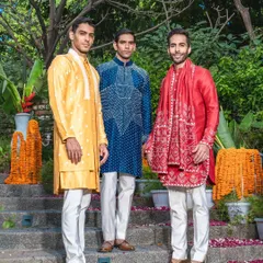 A vibrant trio of kurta sets in yellow, blue, and red. Each piece showcases a different style of embroidery and design, perfect for standing out during the wedding season.