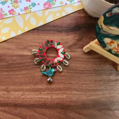 A selection of my Navratri-themed hair brooches and pins. These feature colorful fabric, mirrors, cowrie shells, and even a small bird charm, perfect for adorning a festive bun.