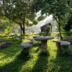 A stone seating area nestled in our garden, bathed in the gentle light of sunrise. It's an ideal spot to start your day with meditation or simply enjoy the peaceful morning atmosphere.
